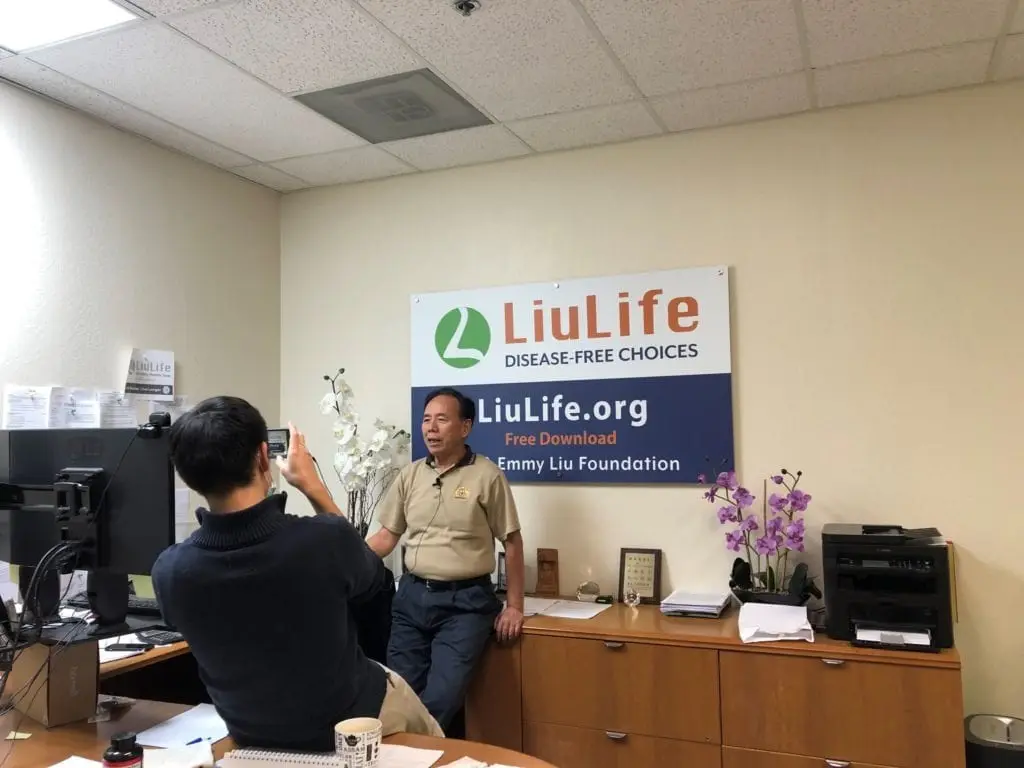 A presentation to a room of attendees under a “Live Life Live Healthier” banner