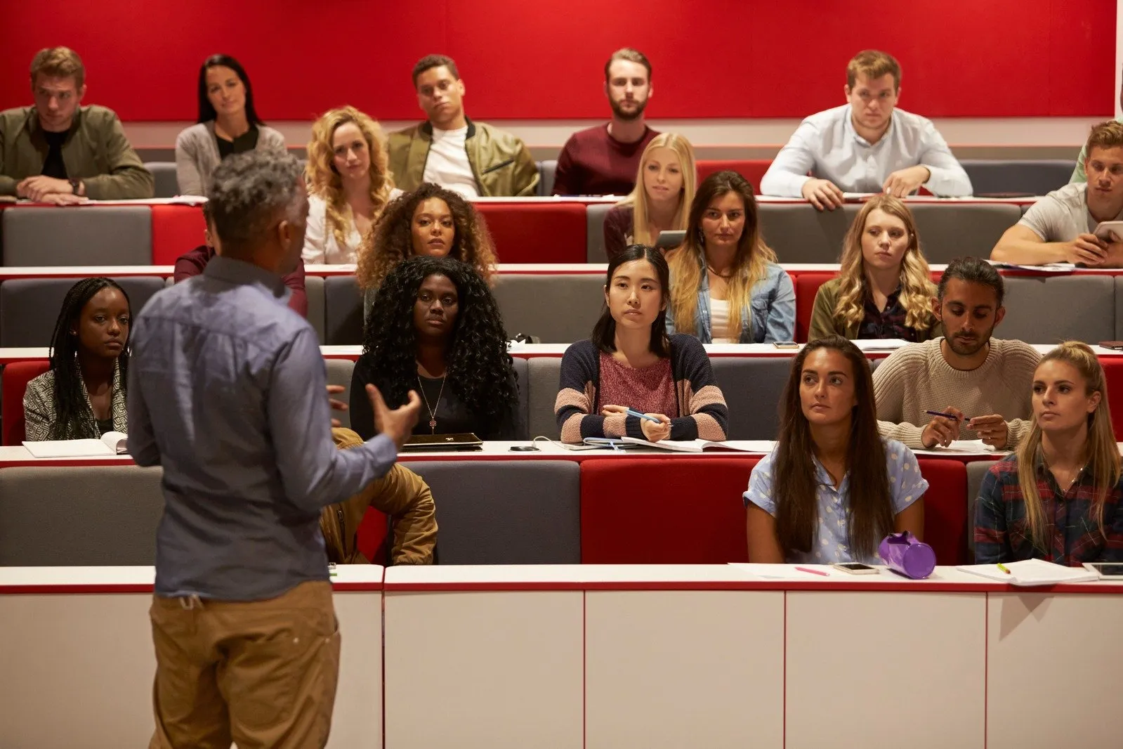 A lecturer speaking to students in a university lecture hall