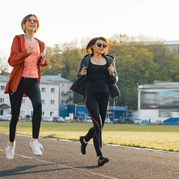 Two women jogging together on a track